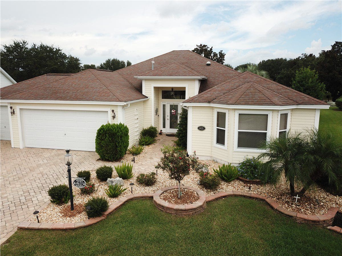 yellow home with red asphalt shingle roof