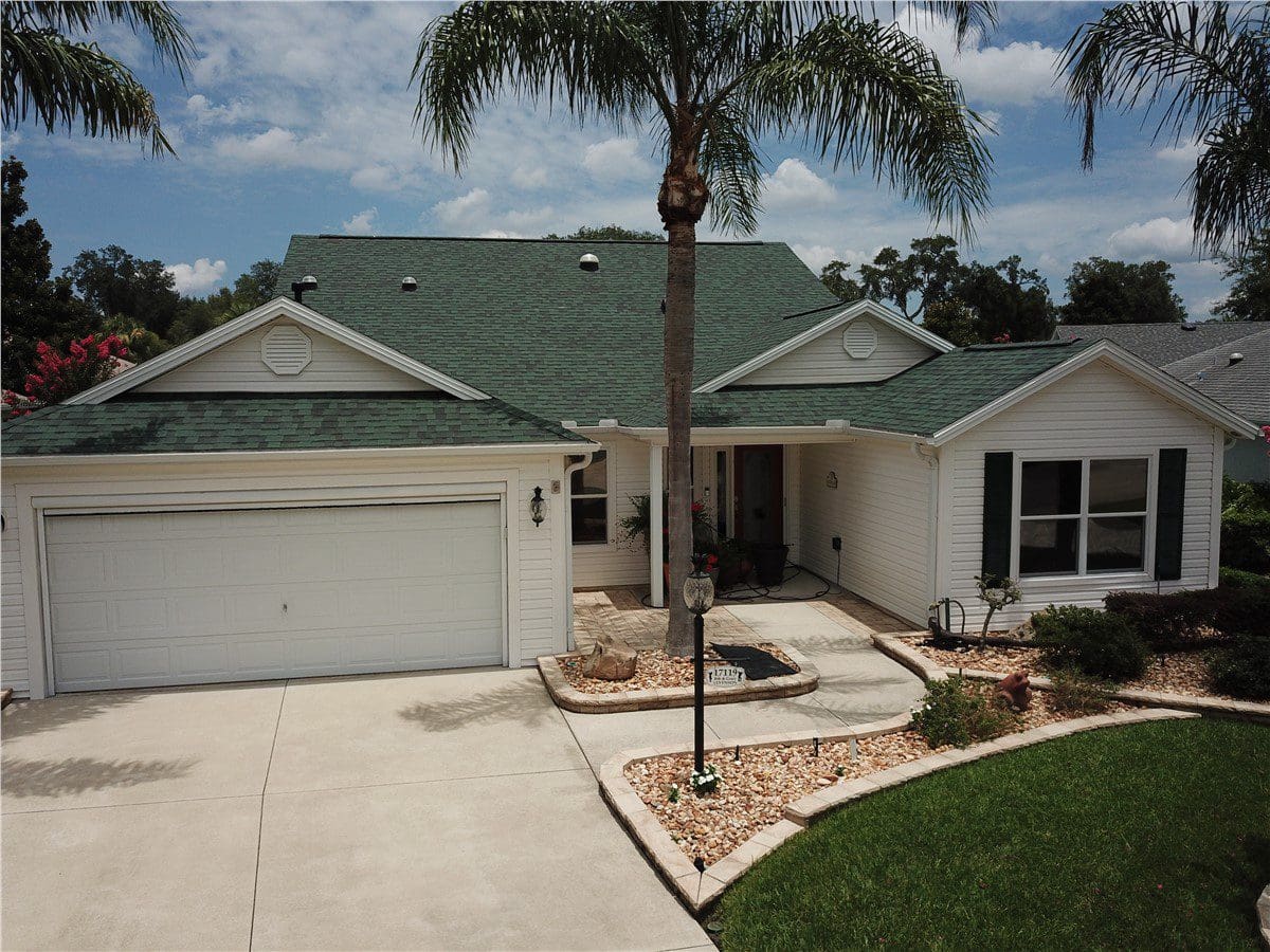 white house with green asphalt shingle roof