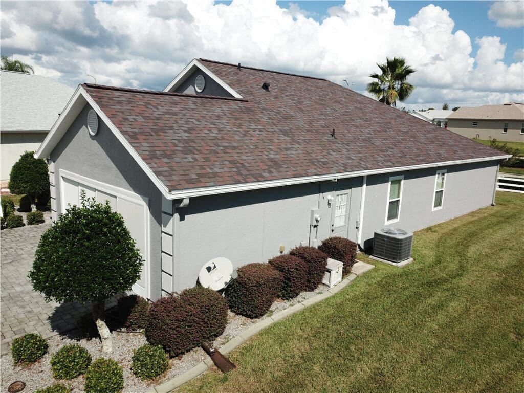 side of gray house with asphalt shingle roof