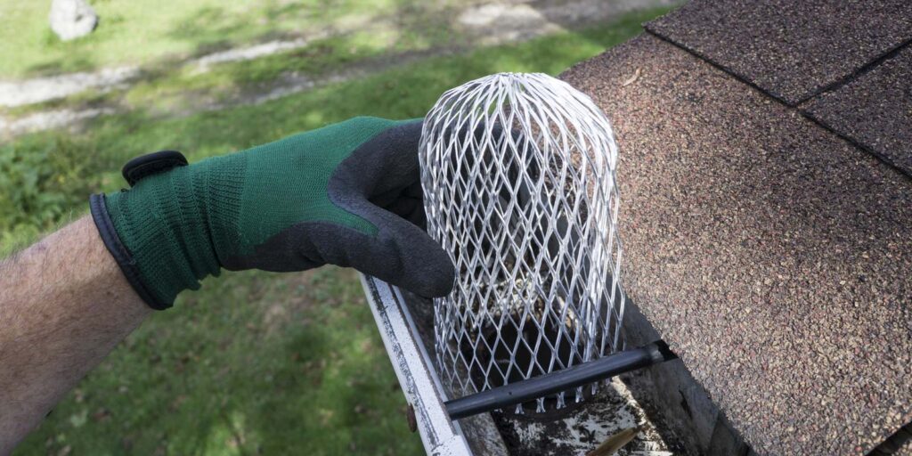 person replacing gutters on a roof