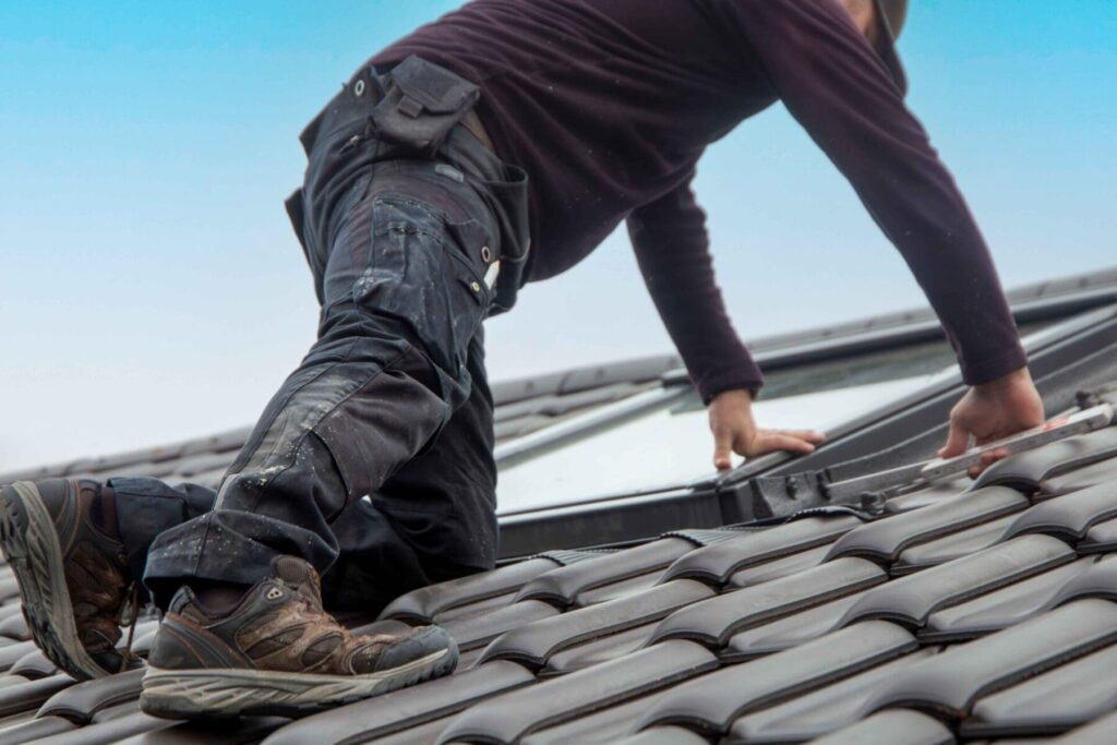 man on top of roof working on a skylight