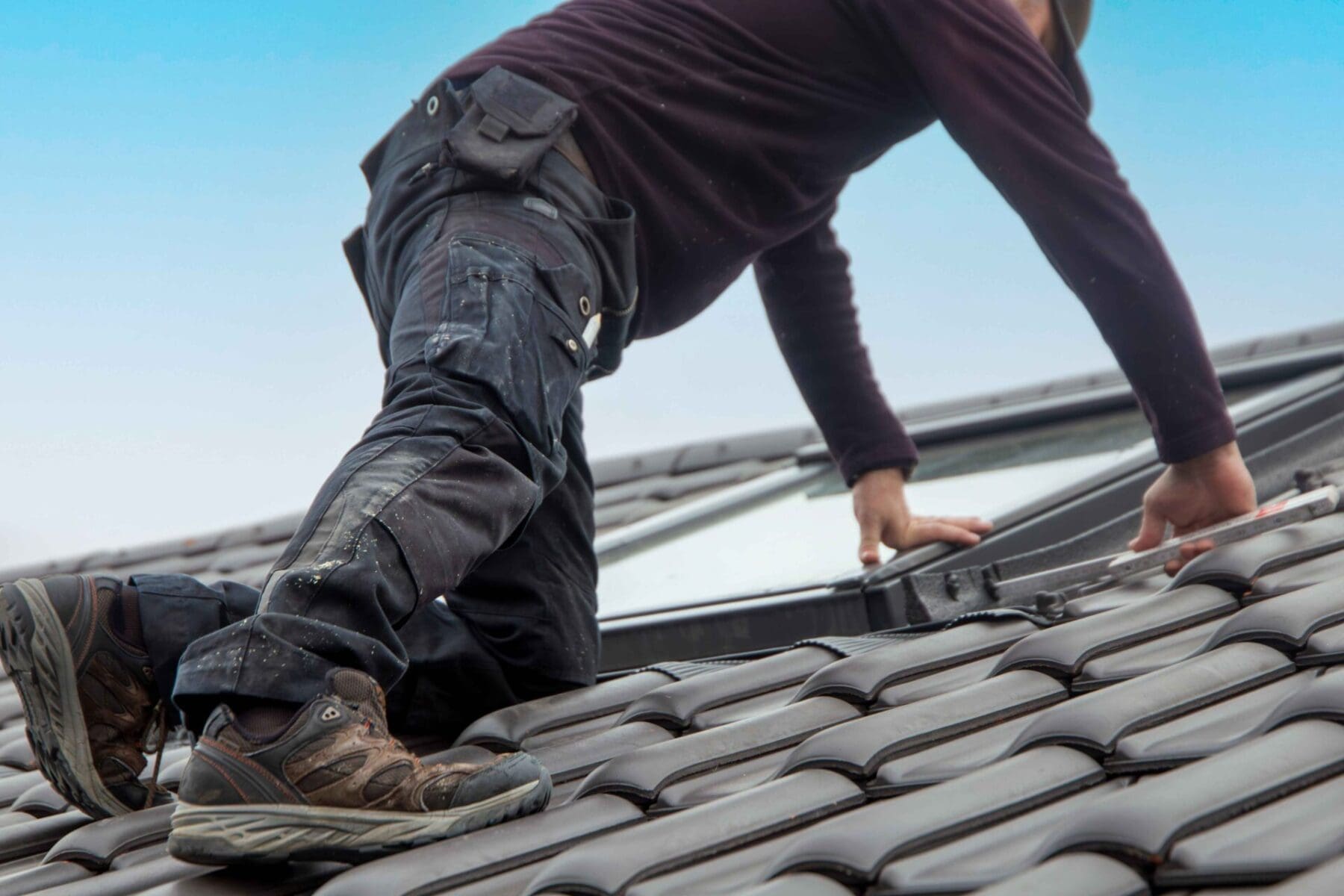 man on top of roof working on a skylight