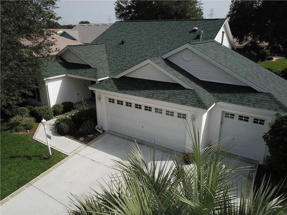 white house with green asphalt shingle roof